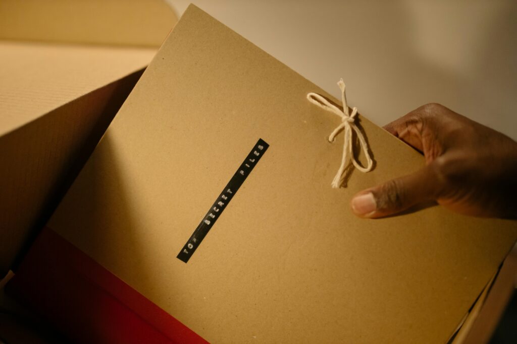 Membership Close-up of hand holding top secret document folder in a box.